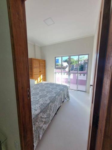 1 dormitorio con cama y ventana en Apartamento Inteiro, novo, no Centro Histórico, en Canavieiras