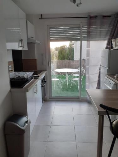 una cucina con tavolo e vista su un patio di La plaine a Saint-Clément-de-Rivière