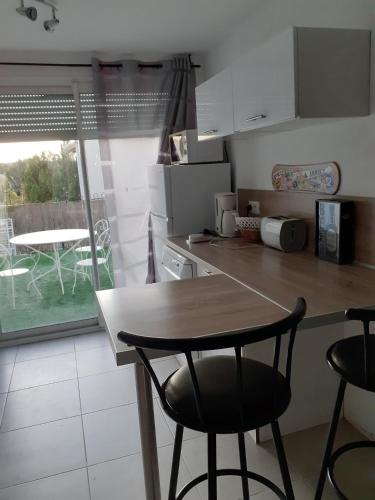 une cuisine avec une table, des chaises et une table dans l'établissement La plaine, à Saint-Clément-de-Rivière