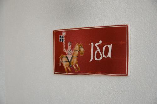 a red sign with a woman on a horse on a wall at Prasini Folia - Traditional Residence in Anogia