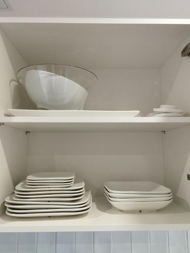 a stack of plates and bowls on a shelf in a refrigerator at Au coucher du lac in Publier