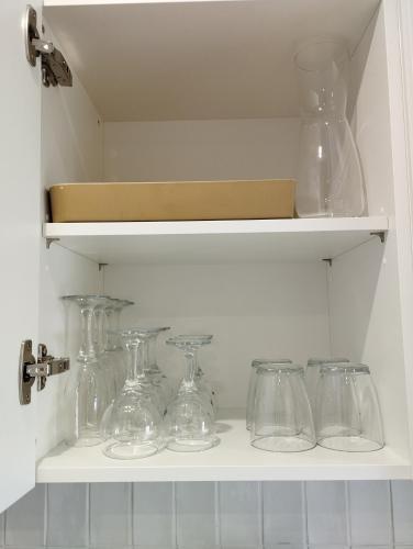 a row of glass jars and vases on a shelf at Au coucher du lac in Publier