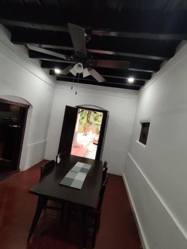 a dining room with a table and a ceiling fan at SuKun Heritage in Kannur