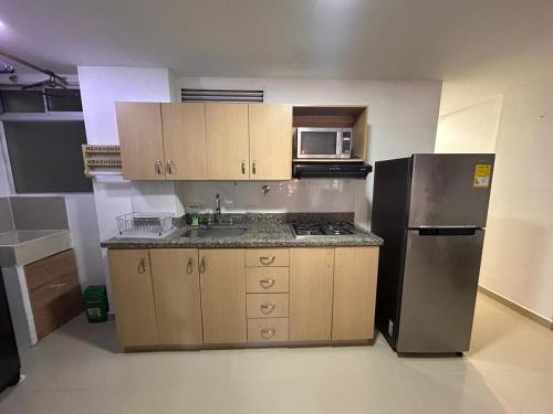 an empty kitchen with a refrigerator and a microwave at Habitación Principal Con Baño Privado in Sabaneta
