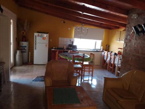 Apart Dos Leones Temporario في تريليو: مطبخ وغرفة معيشة مع طاولة وكراسي