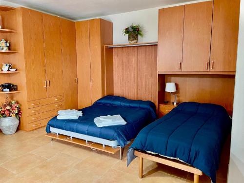 two beds in a room with wooden cabinets at Casa vacanze Il Poggio in Fabro