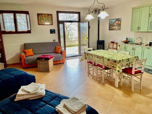 a kitchen and living room with a table and a couch at Casa vacanze Il Poggio in Fabro