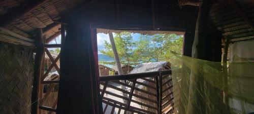 a window in a building with a view of a tree at Bice Camp Darocotan in El Nido