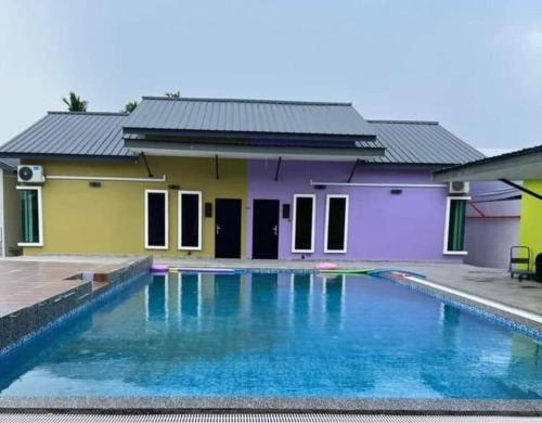uma casa com uma piscina em frente em D Sayang Homestay Parit Buntar MUSLIM SAHAJA em Parit Buntar