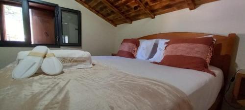 ein Schlafzimmer mit einem großen weißen Bett mit roten Kissen in der Unterkunft Refúgio do Limoeiro in São Vicente