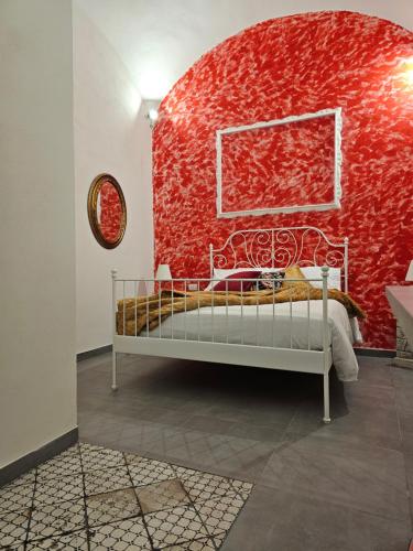 una parete rossa con un letto in una camera di Le Moire Apartments a Ercolano