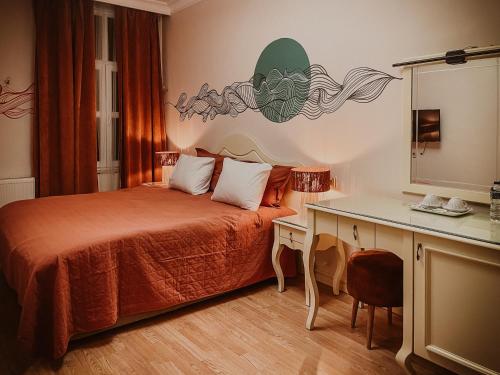 Dervish Han Boutique Hotel في إسطنبول: غرفة نوم مع سرير ومكتب مع مرآة
