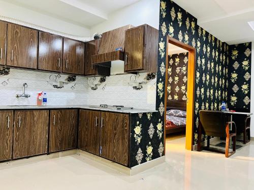 een keuken met houten kasten en een eetkamer bij Highrise Apartments in Gujrānwāla