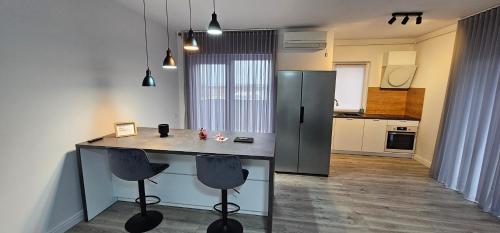 a kitchen with a counter and two bar stools at Lotus in Giarmata Vii