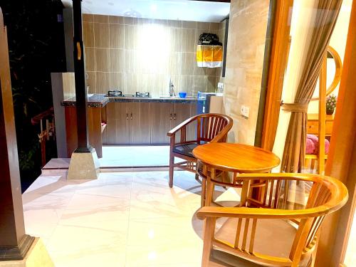 a room with a table and chairs and a kitchen at Ayu Homestay in Ubud