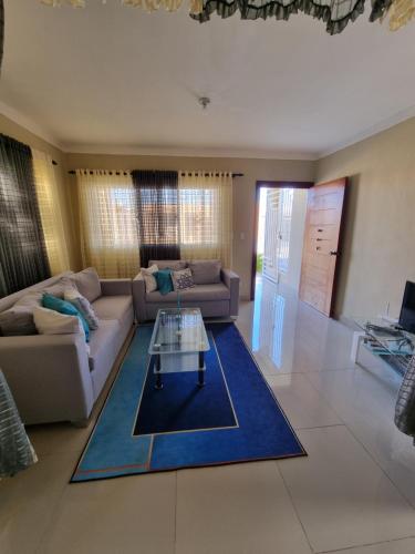 a living room with a couch and a table on a blue rug at Ferienhaus La Romana in La Romana