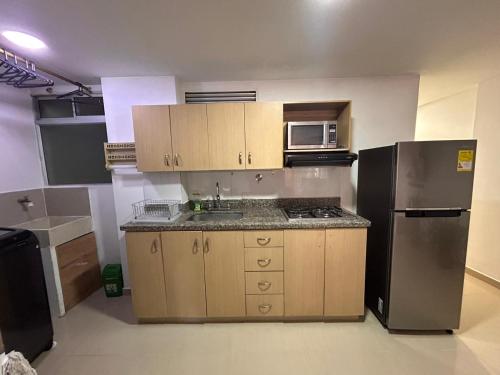 a kitchen with a sink and a refrigerator at Habitacion Con Balcon Privado in Sabaneta