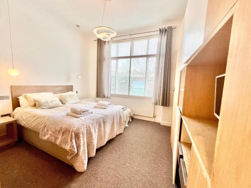 ロンドンにあるStylish 2BR Designer Flat Holland Parkのベッドルーム1室(ベッド1台、大きな窓付)