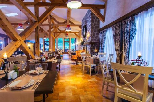 Un restaurante con techos de madera y mesas y sillas. en Spacious luxury studio with mountain view - SPA available, en Bansko