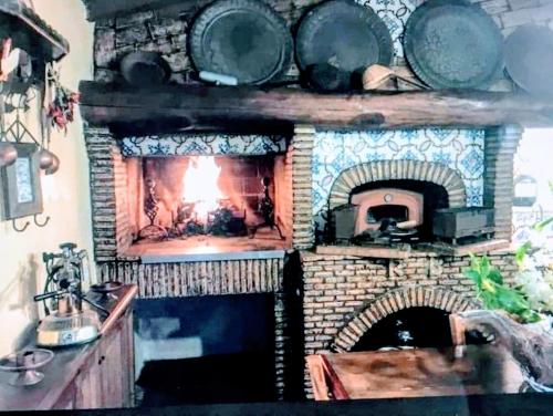 a brick fireplace with a fire in it at Rome villa swimming pool in Campagnano di Roma