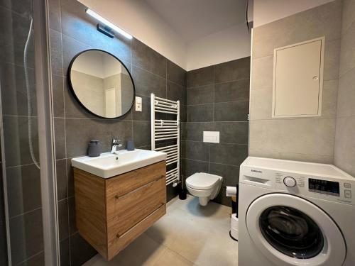 a bathroom with a sink and a washing machine at Quiet Apartment with Garden and Free Parking in Trnava