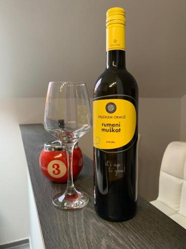 a bottle of wine and a glass on a table at Prenoćište Šimić in Slavonski Brod