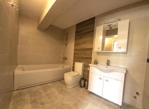 a bathroom with a tub and a toilet and a sink at Efes Hidden Garden Resort Otel in Selcuk