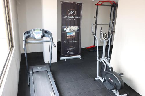 a room with a gym with a treadmill and a door at Hotel San Agustin Plaza in Latacunga