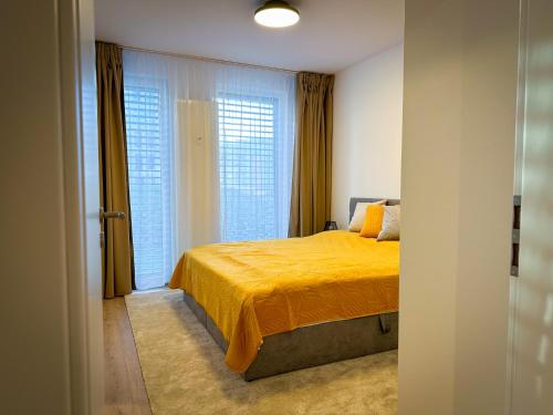 sypialnia z żółtym łóżkiem i oknem w obiekcie Quiet Apartment with Garden and Free Parking w mieście Trnava