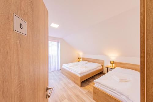 two beds in a room with a door open at Chalupa KARKULKA in Hostice
