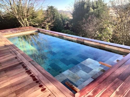 una piscina con terrazza in legno e una piscina di Unique ! villa piscine/parc arboré centre Bayonne a Bayonne