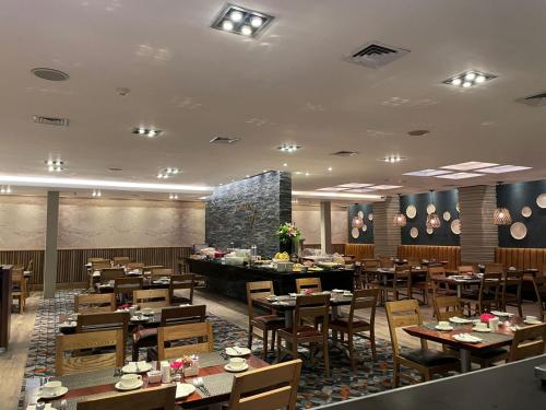 a restaurant with tables and chairs in a room at Southern Sun Newlands in Cape Town