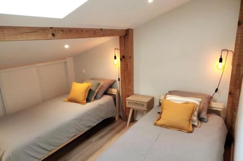 - 2 lits dans une petite chambre avec des oreillers jaunes dans l'établissement Unique ! villa piscine/parc arboré centre Bayonne, à Bayonne