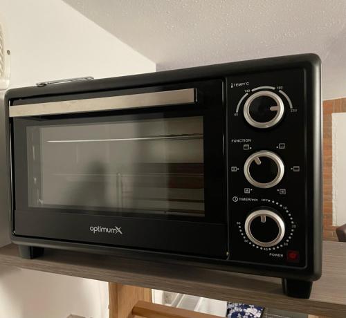 a black toaster oven sitting on top of a counter at Schönes Apartment mit TV, WLAN, Kochbereich und Parkplatz - Sara in Werne an der Lippe