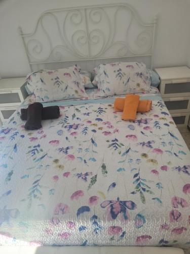 Una cama con una colcha con flores. en Piso para compartir, en Santa Coloma de Gramenet