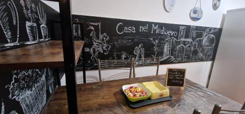 a table with a box of candy and a chalkboard at casa medioevo in Viterbo