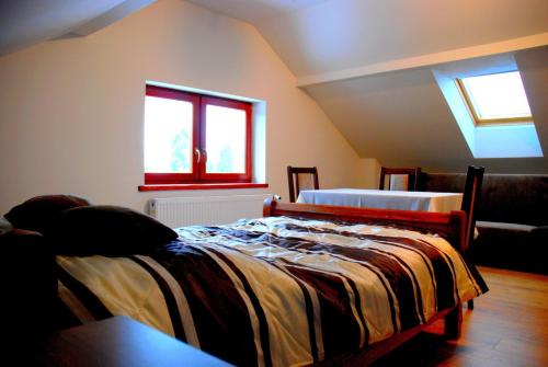 a bedroom with two beds and a window at Hortensja in Iława