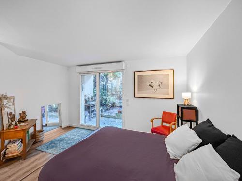 une chambre avec un grand lit et une fenêtre dans l'établissement Charmant Appartement au Cœur de Boulogne, à Boulogne-Billancourt