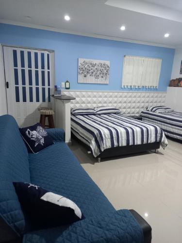 2 camas en un dormitorio con paredes azules en Holiday Loft Suite Apartamento, en San Andrés