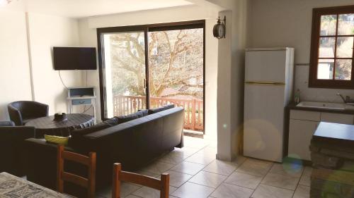 ein Wohnzimmer mit einem Sofa, einem Tisch und einem Kühlschrank in der Unterkunft Grands appartement à Ciboure in Ciboure
