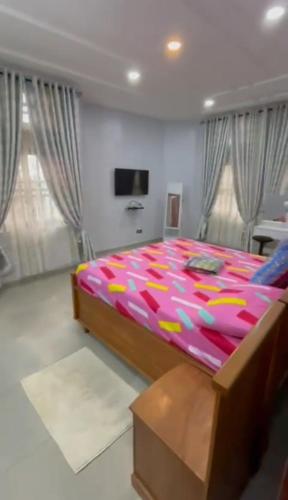 een slaapkamer met een groot bed en een kleurrijk dekbed bij Appartement en diamant in Porto-Novo