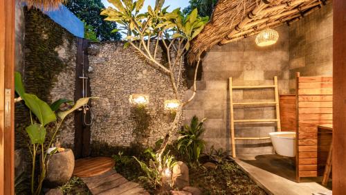 a bathroom with a toilet and some plants at Ganesh Villa in Ubud