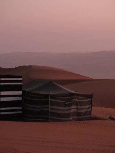 a tent in the sand in the desert at Arab desert camp in Al Raka