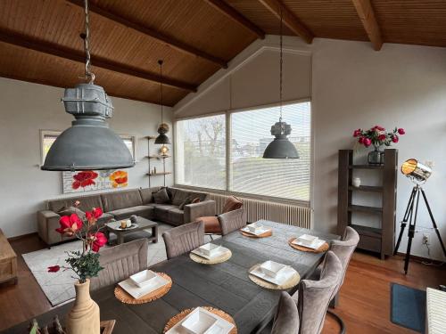 a living room with a table and a couch at Beach House Wantveld Noordwijk aan Zee in Noordwijk aan Zee