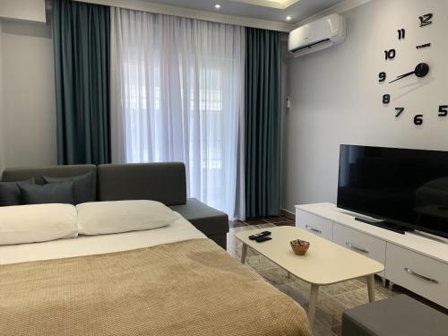 a bedroom with a bed and a tv and a couch at Fishta Quality Apartments Q5 31 in Velipojë