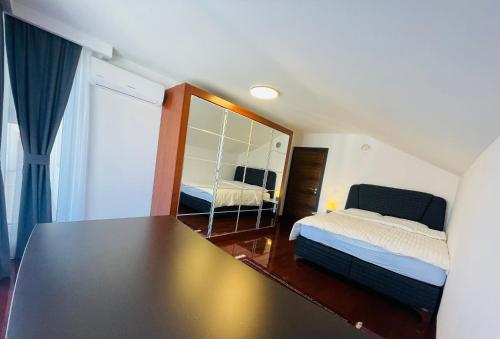 ein kleines Schlafzimmer mit einem Bett und einem Spiegel in der Unterkunft SOHO Pristina Kosovo in Pristina