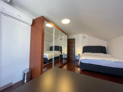 a bedroom with two beds and a mirror at SOHO Pristina Kosovo in Prishtinë