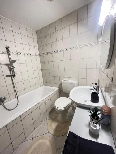 a white bathroom with a toilet and a sink at Maisons du Souihel in Recklinghausen