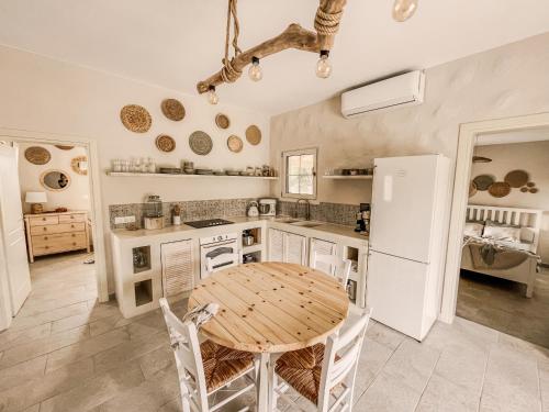 a kitchen with a table and a white refrigerator at Villa Elia in Peroulades