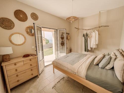 a bedroom with a bed and a dresser and a window at Villa Elia in Peroulades